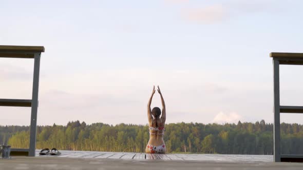 A Beautiful Woman Stretches on the Pier