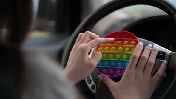 Woman Using Pop It or Simple Dimple in Car