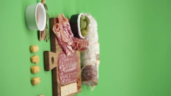 Vertical video, Close-up: cold cuts, salami, prosciutto, jamon, cherry tomatoes, sliced ​​sausage