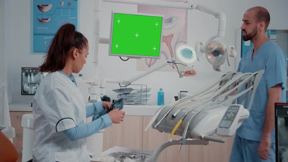 Dentist Receiving Teeth Scan From Man While Looking at Green Screen