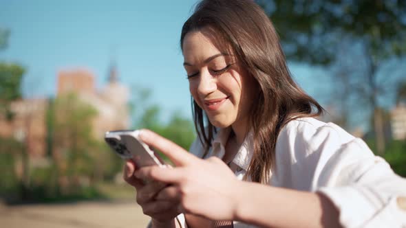 Laughing brunette woman typing on mobile