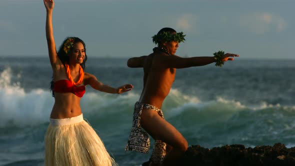 Polynesian dancers perform by ocean, slow motion