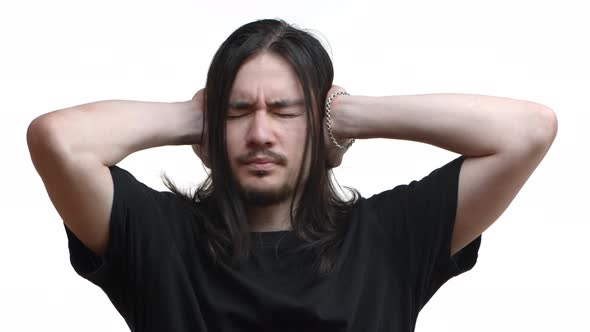 Closeup of Distressed Young Eastasian Bearded Guy with Long Hair and Piercing Shaking Head in Denial