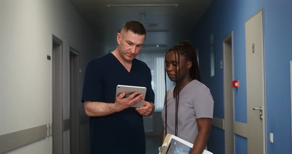 A Doctor Shows His Colleague Something on a Tablet Screen