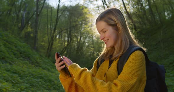 The Girl Is Looking at the Maps on the Smartphone