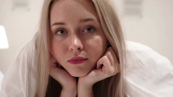 Close Up of Serious Face of Beautiful Woman in Bed