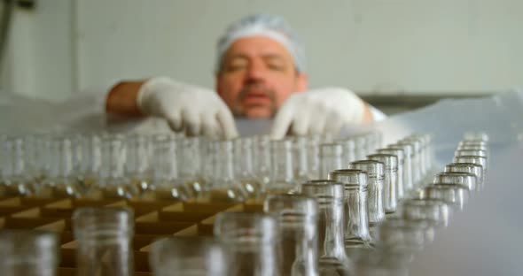 Male worker holding bottles in factory 4k