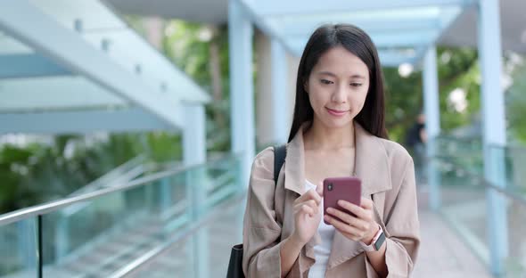 Asian woman sending sms on mobile phone