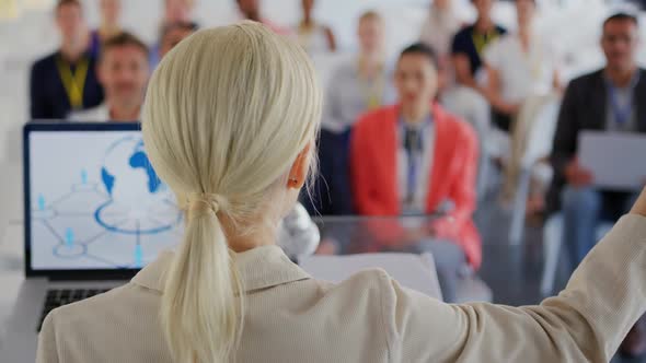 Female speaker adressing the audience at a business conference