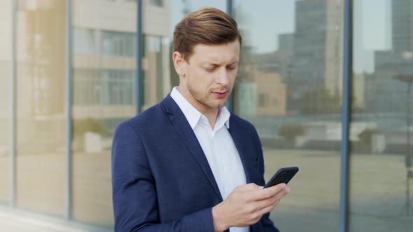 Businessman Using Smartphone at Street. Entrepreneur Texting on Mobile Phone