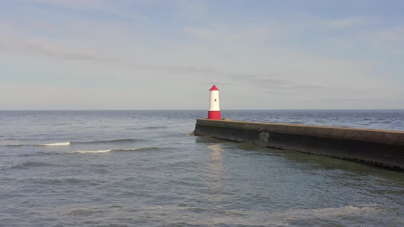 A Lighthouse and Breakwater at the Mouth of a Harbour in the UK