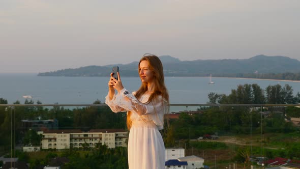 Travel Woman on Rooftop with Sea View and Recording Video on Mobile Phone