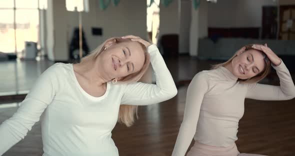 Pregnant Woman and Her Personal Trainer Doing Stretching Exercises