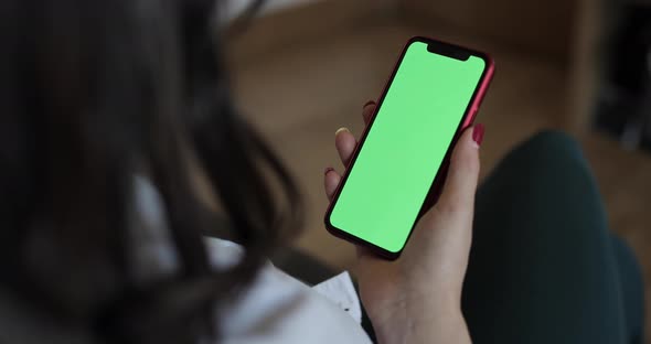 Woman using a smart phone with green screen