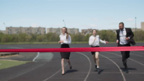 Businessmen Run Through Stadium in Office Clothes a Young Businesswoman Crosses the Red Finish Line