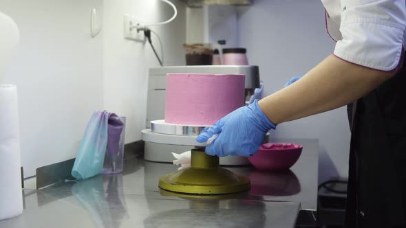 Spinning a Purple Cake on Special Tray While Finishing Up Decorating It