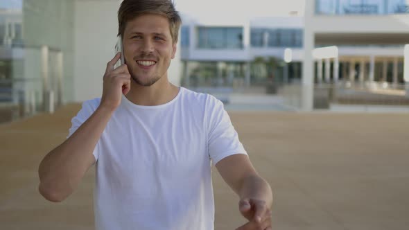 Successful Young Man Talking on Phone During Stroll