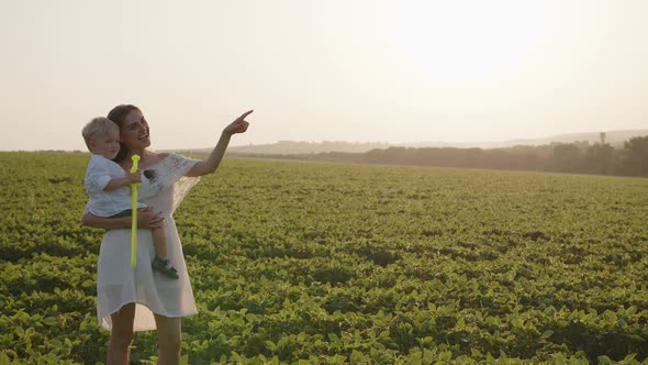 Beautiful Mother with Her Son in a Field