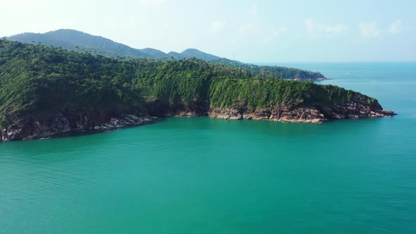 Aerial flying over landscape of tranquil resort beach holiday by aqua blue sea and clean sandy backg