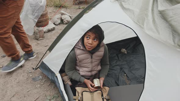 African-American Girl with Tinned Food in Tent at Refugee Camp