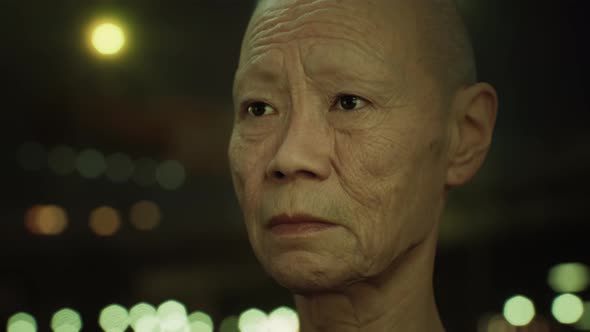 Old Asian Woman in City at Night alt