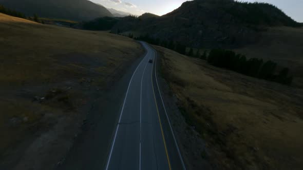 FPV Sports Drone Shot Flying Over Mountain Road Dry Grass Texture Sunset