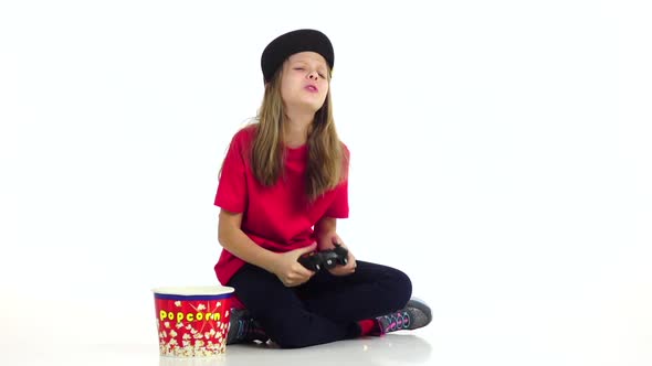 Teen Plays Joystick in Online Game, Eats Popcorn. Slow Motion