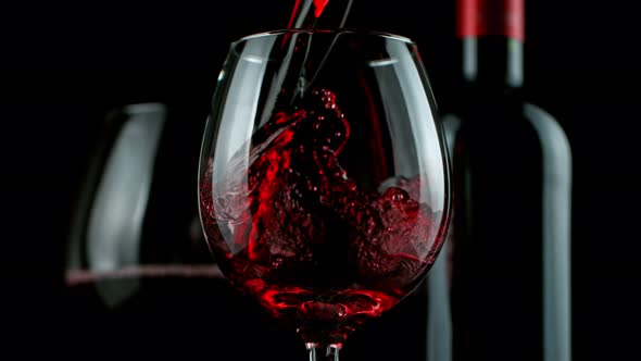 Super Slow Motion Detail Shot of Pouring Red Wine on Black Background at 1000Fps