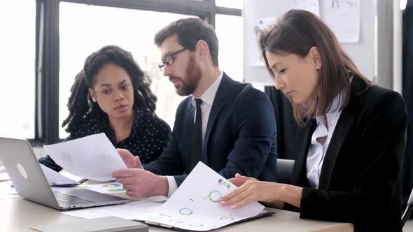 Intelligent Pretty Caucasian Young Adult Brunette Business Lady in Suit Sitting at the Workplace in