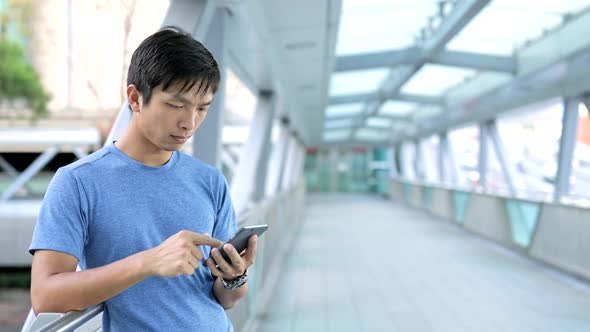 Young Man using cellphone in city 