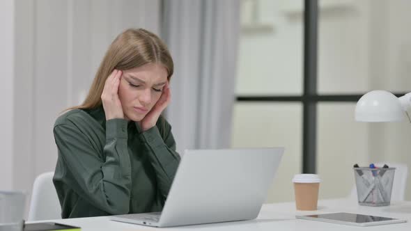 Young Woman with Headache Working on Laptop