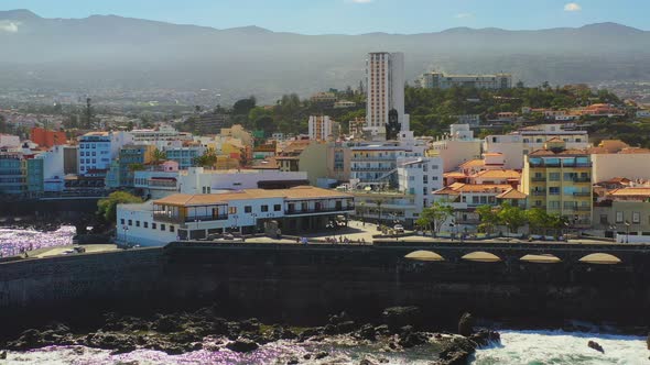 Tourists walking in the harbor of Puerto de la Cruz, Tenerife, Canary Islands, its stone piers, rock