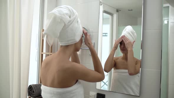 Face Skin Care. Woman Applying Cream On Skin At Bathroom
