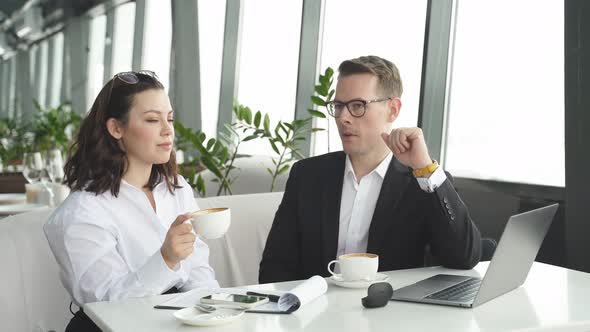 Business Caucasian People Talking at Meeting in Restaurant They Sit with Laptop at Table Coworking