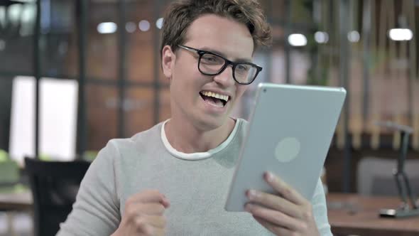 Portrait Shoot of Successful Guy Celebrating While Using Tablet