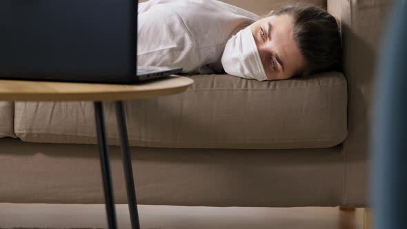 Sick Bored Woman with Laptop Lying on Sofa at Home