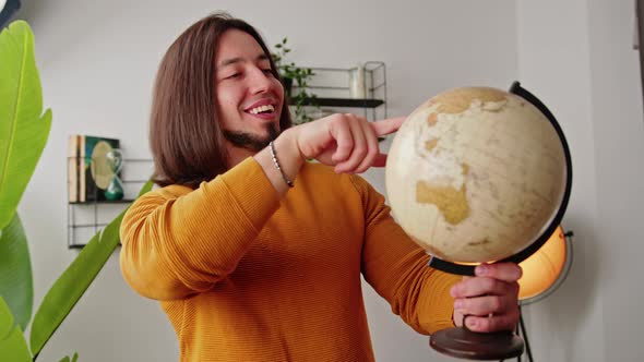 Bearded Brunet Guy with Long Hair Planning His Future Travel Destinations with Artificial Plastic