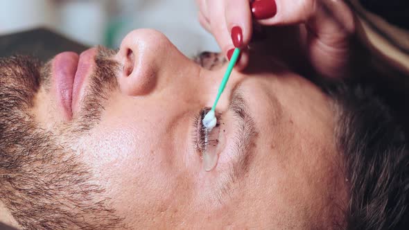 Beautician Paints Eyelashes to a Client Male