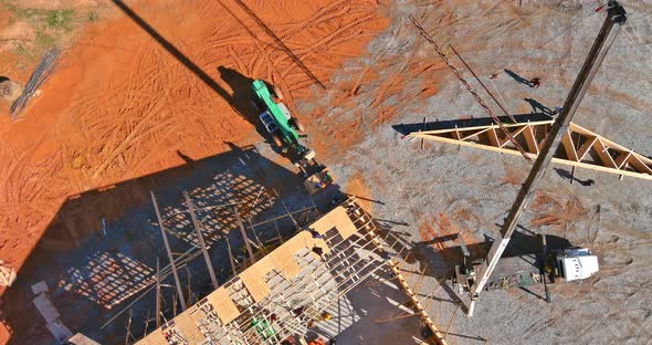 Under Construction on the Roof an Top View Crane Holds Beams Roof Trusses of Timber Frame