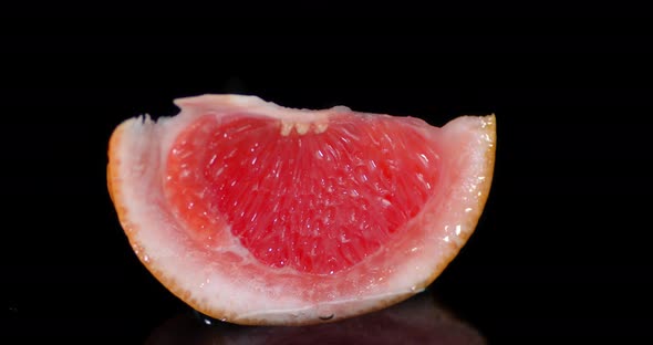 A Piece of Grapefruit Falls Into the Water with Splashes. 