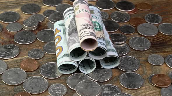 American Dollars Banknotes Rolled Into Tube and Us Coins Rotate Slowly