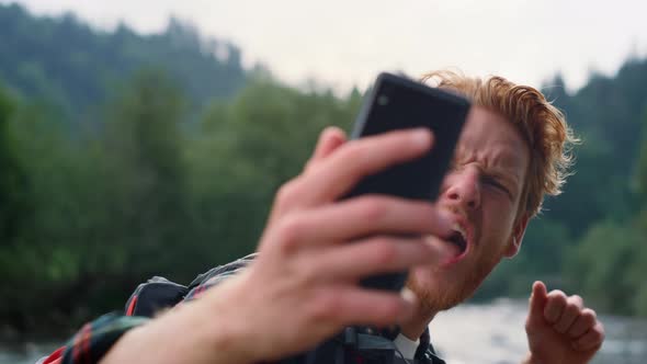 Hiker Taking Selfie on Phone in Mountain Landscape