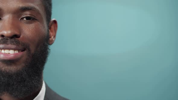 A Young Handsome Black Bearded Man in a Tuxedo is Smiling and Looking at the Camera