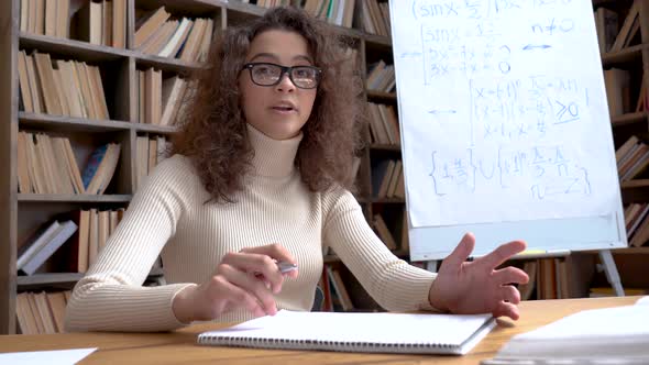 Young Hispanic School Math Teacher Looking at Webcam Virtual Teaching