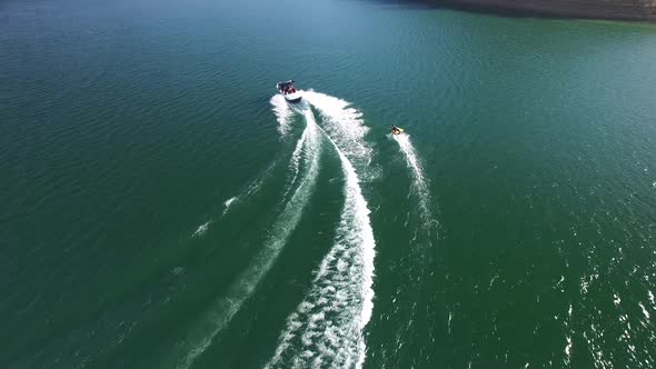 A nice summer day out on the lake enjoying some watersports with boats and personal watercraft.