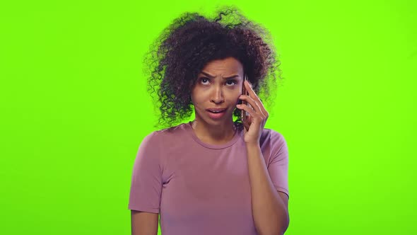 Young African American Woman Gossip Emotionally Talking on Phone in Green Studio