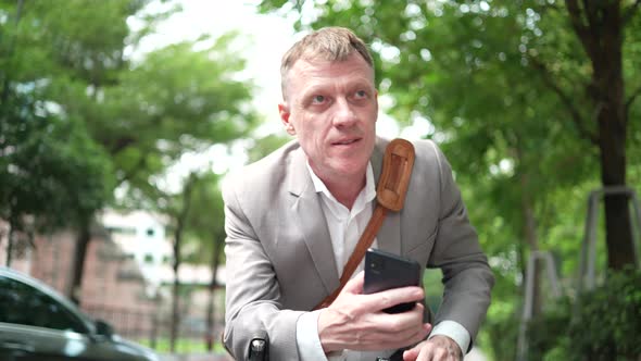 Businessman with bicycle waiting to meet someone on street in the city