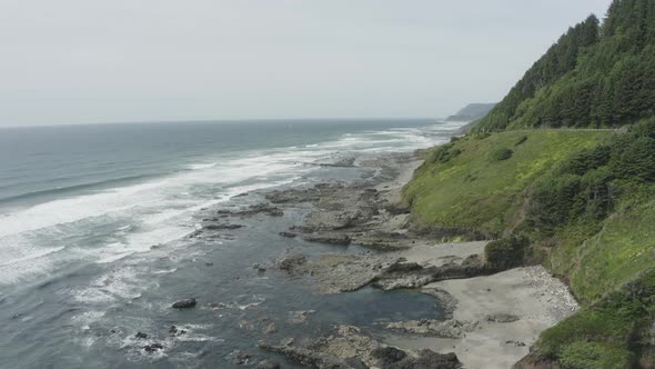 Slow dropping pan of rocky Oregon coastline waves and rocky cliffs