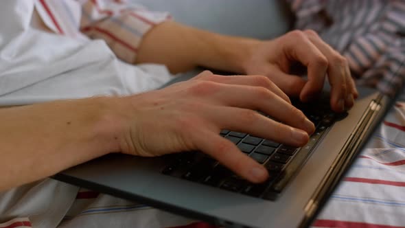 Freelancer Hands Typing Laptop Keyboard in Pajamas Closeup