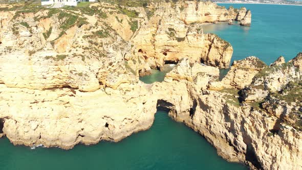 Ponta da Piedade Lighthouse, aerial approaching cliff formations along coastline of Lagos